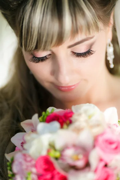 Porträtt av en vacker brud med en bukett blommor — Stockfoto