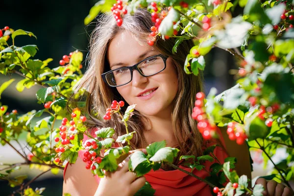 Portrait of a beautiful girl  in glasses near the red viburnum — Stock Photo, Image