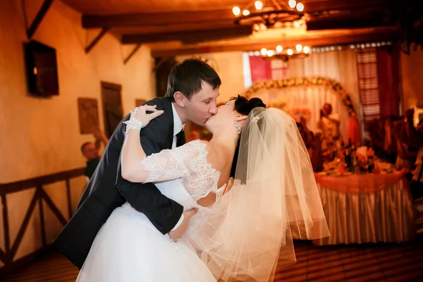 Kussen en dans van de jonge bruid en bruidegom in Banquet hall — Stockfoto