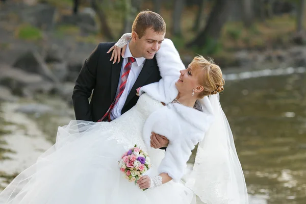 Noivo e a noiva durante a caminhada em seu dia do casamento — Fotografia de Stock