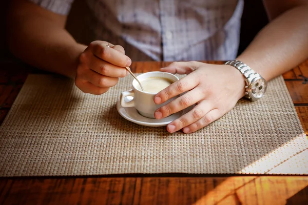 Knappe jongeman drinken koffie. Close up van man zitten in Cafe en houden cup — Stockfoto