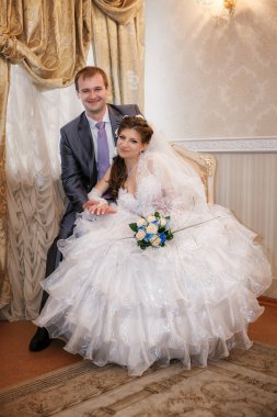 Güzel damat ve gelin düğün günü iç kısımda oturuyor.