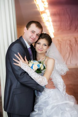 Damat ve gelin düğün buket ile beyaz bir sütun stand