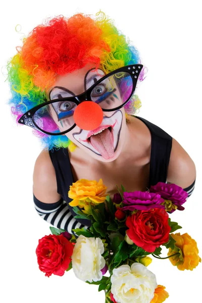 Menina em grandes óculos vermelhos e traje de palhaço com um buquê de flores coloca a língua olha para cima — Fotografia de Stock