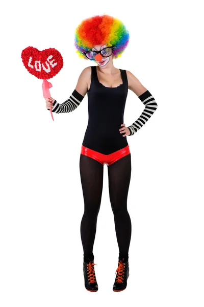 Girl in a clown suit holding a red heart — Stock Photo, Image