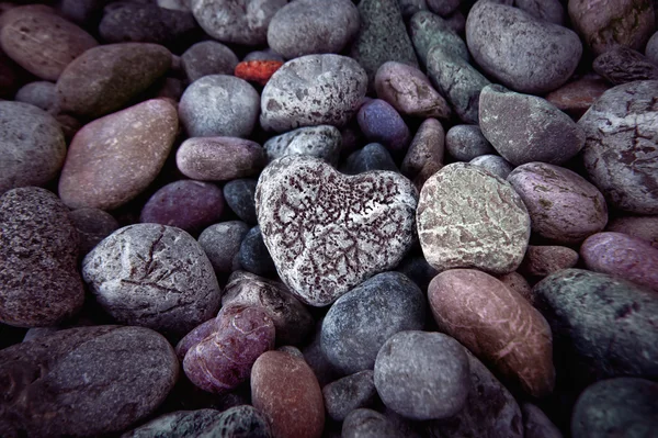 Cuore singolo su pietre di ciottoli neri — Foto Stock