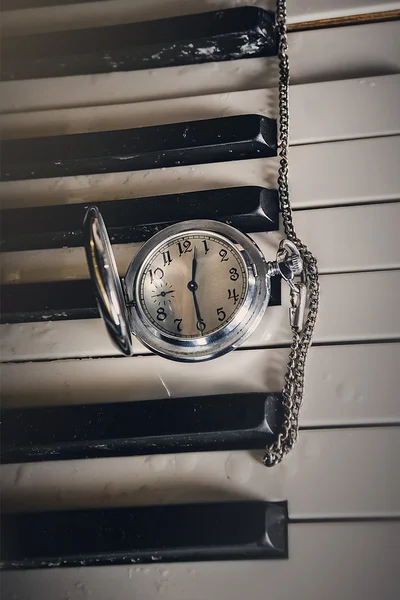 Pocket watch on old keyboard piano — Stock Photo, Image