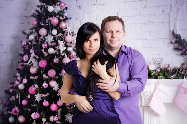 Hombre y mujer en la habitación con árbol de Navidad y chimenea —  Fotos de Stock