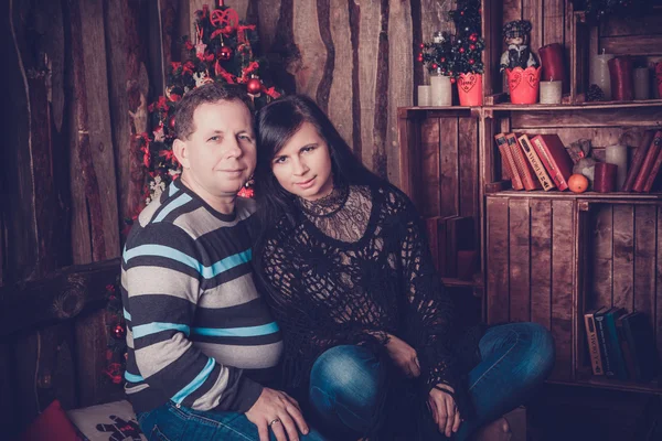 Casal amoroso sorrindo ao lado de sua árvore de natal em casa — Fotografia de Stock