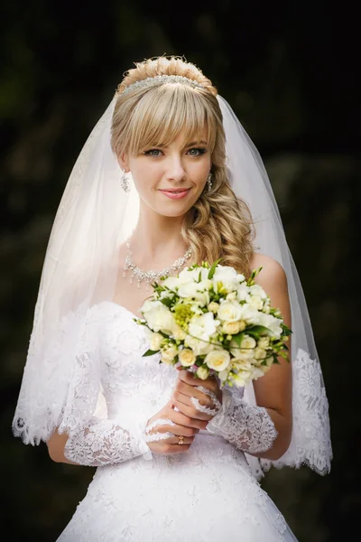 Portrait of a beautiful blonde bride with wedding bouqet in the hands — Stock Photo, Image