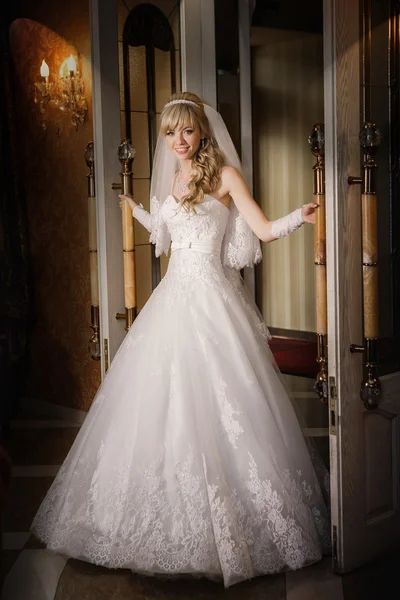 Hermosa novia sexy rubia en un vestido blanco está dejando la puerta —  Fotos de Stock