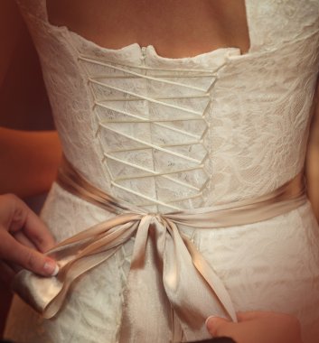 Gelin beyaz düğün elbisesini giyiyor