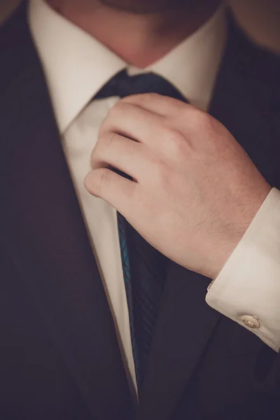 Businessman in suit is tying the necktie — Stock Photo, Image