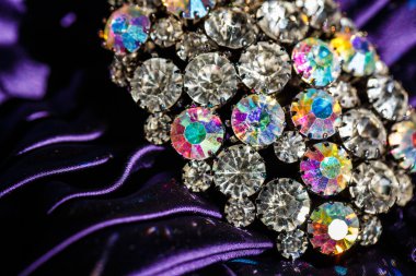 Menekşe kumaş üzerine parlak taşlarla broş