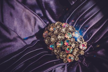 Menekşe kumaş üzerine parlak taşlarla broş