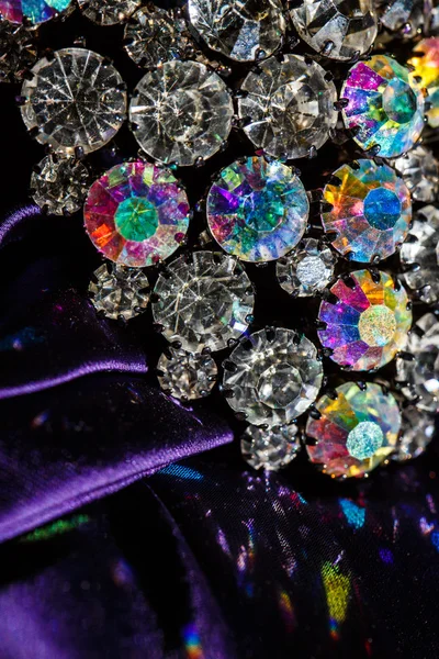 Brosch med lysande stenar på lila tyg — Stockfoto
