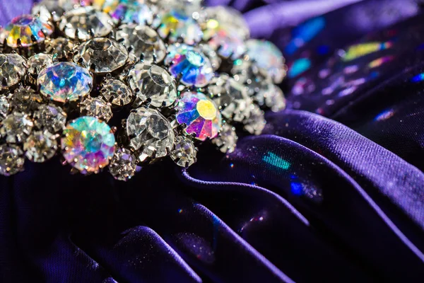 Broche com pedras brilhantes em tecido violeta — Fotografia de Stock