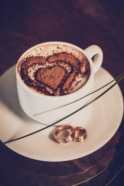 Kopje koffie, trouwringen en bruiloft boeket tulpen — Stockfoto