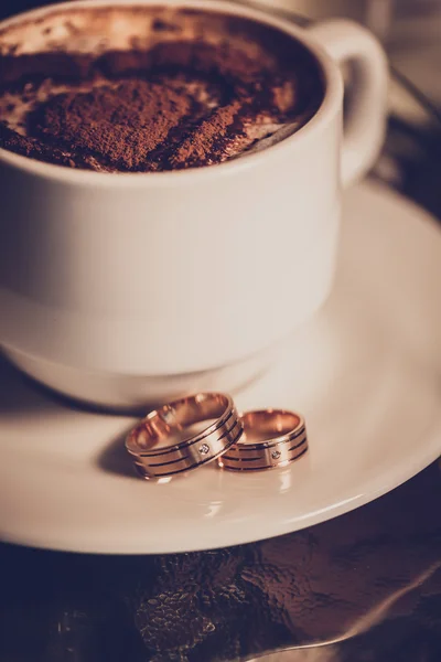 Kopje koffie, trouwringen en bruiloft boeket tulpen — Stockfoto