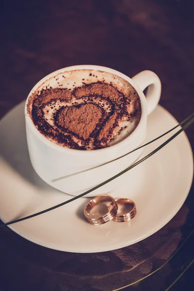 Tasse Kaffee, Trauringe und Tulpenstrauß Stockfoto