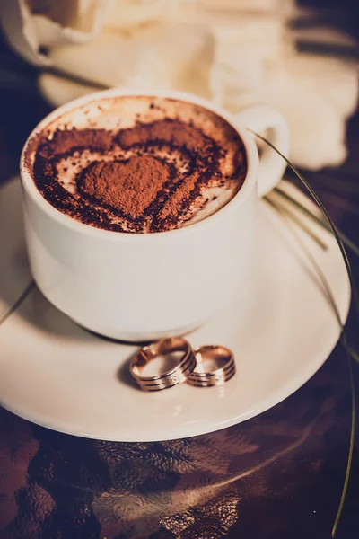 Tasse Kaffee, Trauringe und Tulpenstrauß Stockbild