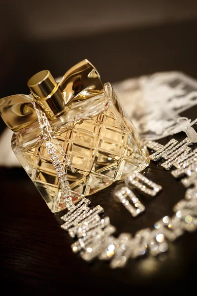 Perfume bottle with necklace and earrings — Stock Photo, Image
