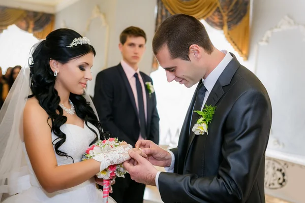 Marié jeunes mariés porte bague mariée lors de la cérémonie de mariage — Photo