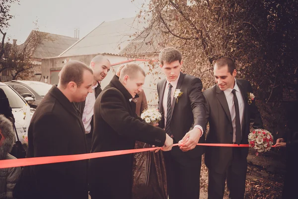 Groom with best man and groomsmen  go to the bride at wedding. Repayment of the bride. Russian custom.