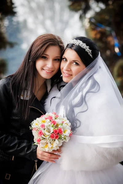 Beautiful bride with her pretty bridesmaid — Stockfoto