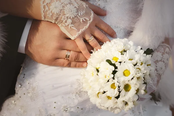 Bride and groom hands with wedding rings and bouquet of white chrysanthemums — Stock Photo, Image