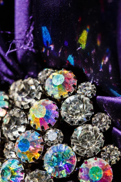 Брошь с блестящими камнями на фиолетовой ткани — стоковое фото