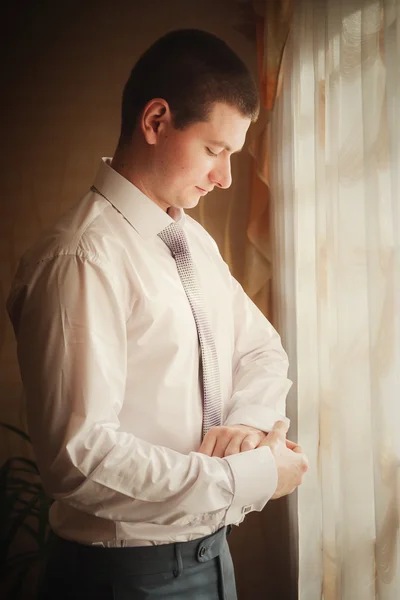 Groom putting on cuff-links as he gets dressed in formal wear close up — Stock Photo, Image