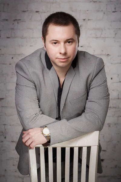 Portrait of handsome man at his office standing near empty chair — ストック写真