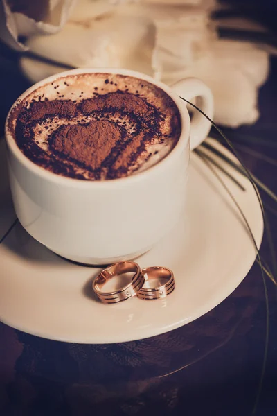Tasse Kaffee, Trauringe und Tulpenstrauß Stockfoto