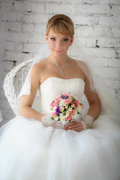 Bride is sitting on a white chair — Stock Photo, Image