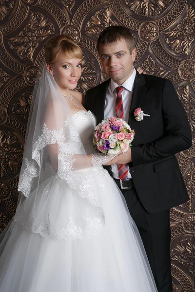 Счастливый жених и очаровательная невеста с букетом из роз — стоковое фото