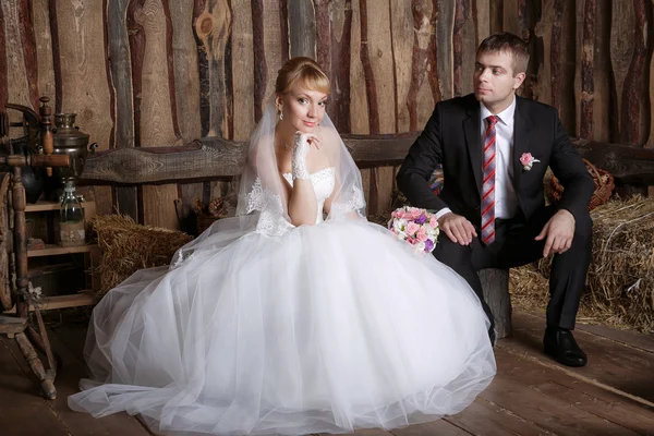 Studio ritratto di sposa e sposo seduto rilassato sulla poltrona il giorno del loro matrimonio — Foto Stock