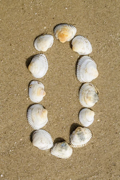 Alfabeto fatto con conchiglie di mare su fondo di sabbia senza soluzione di continuità — Foto Stock