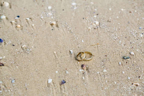 Conceito de casamento - alianças de casamento estão na areia — Fotografia de Stock