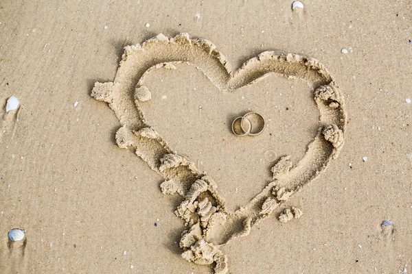 Wedding rings lie in the sand — Stock Photo, Image