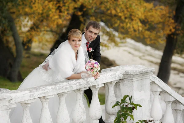 Noivo e a noiva durante a caminhada em seu dia do casamento — Fotografia de Stock