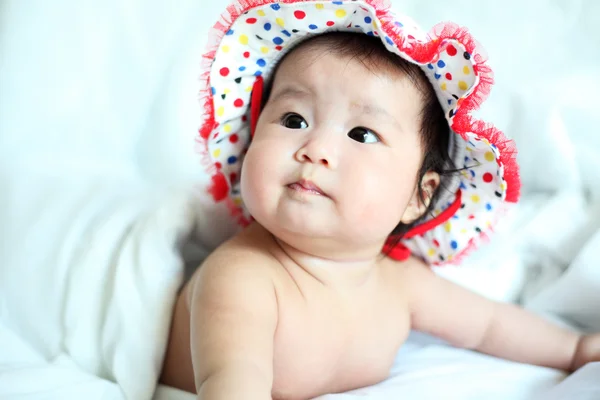 Newborn Baby with Colorful Floppy Hat Lying Down on a White Blan — Stock Photo, Image
