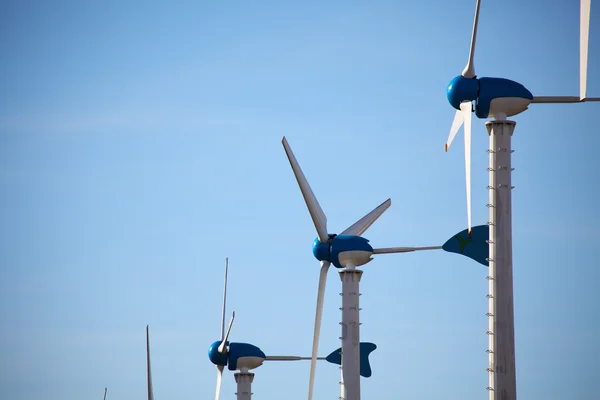 Green renewable energy concept - wind generator turbines on blue — Stock Photo, Image