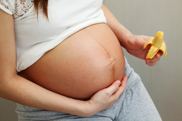 Mulher grávida segurando banana — Fotografia de Stock
