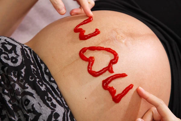 Word Mom Written on Pregnant Belly — Stock Photo, Image