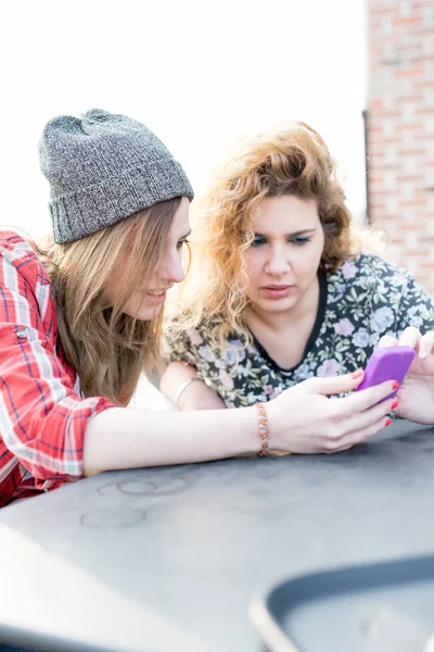 Mujeres sentadas en el bar, usando teléfono inteligente — Foto de Stock