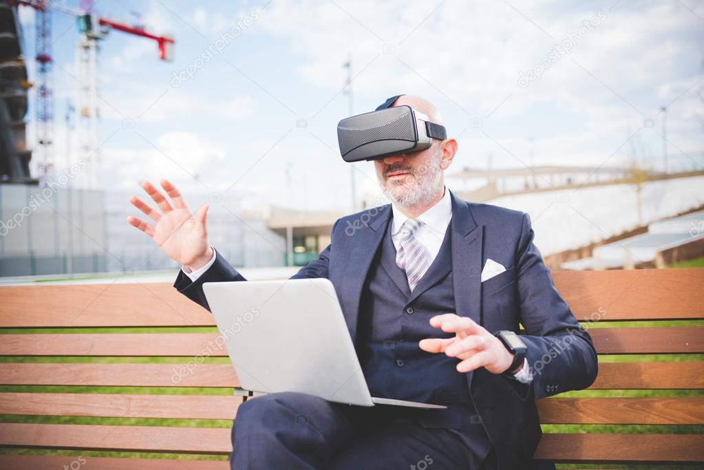 businessman sitting on bench using 3D viewer