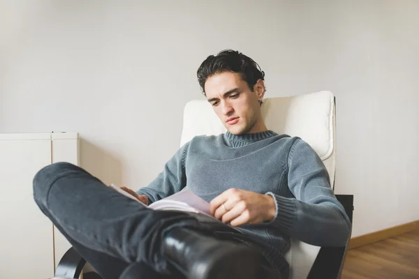 Hombre sentado en sillón en casa — Foto de Stock