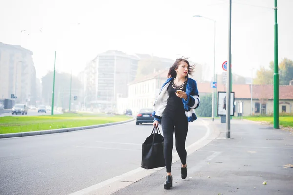 Östra kvinna promenader utomhus i staden — Stockfoto