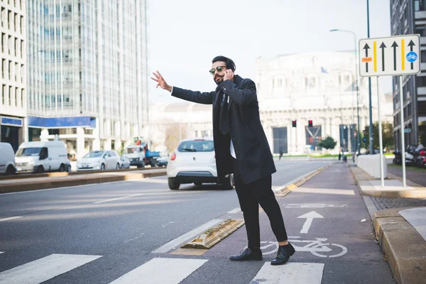 Uomo d'affari ne su smartphone e alla ricerca di taxi — Foto Stock